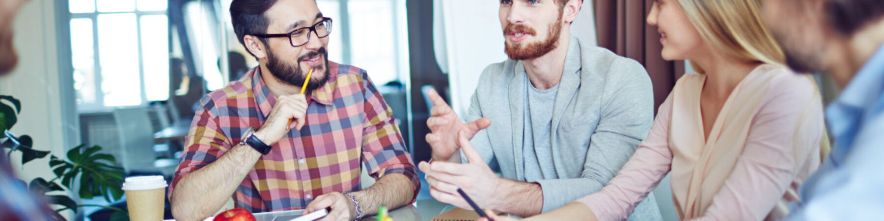 Business team looking at young man talking about new tendencies Business team looking at young man talking about new tendencies